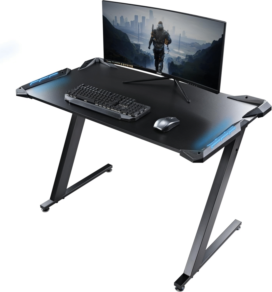Eureka Ergonomic Z1-S Gaming Desk featuring a cable tray, controller rack, cup holder, and sleek carbon fiber top for gaming setups in small spaces