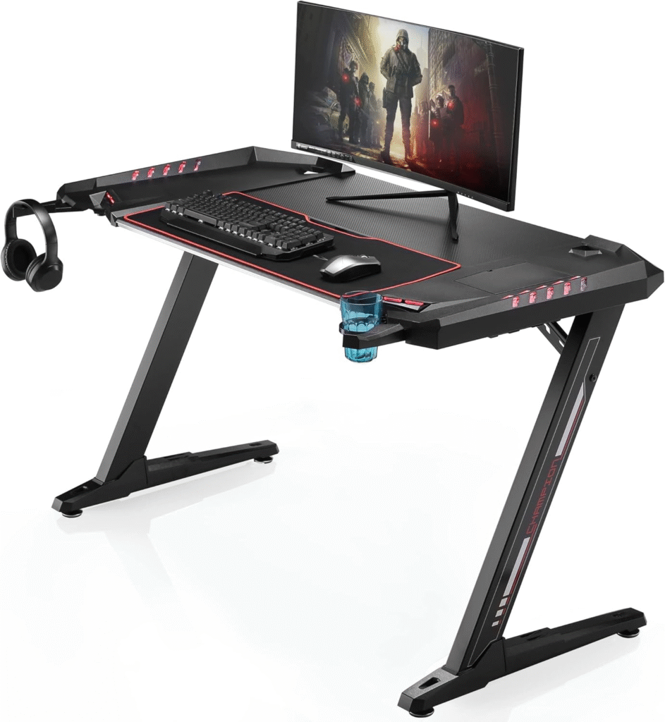 Eureka Ergonomic Z2 Gaming Desk showing carbon fiber finish, RGB edge lighting, headset hook, and under-desk cable channel